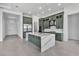 Modern kitchen featuring sleek, sage green cabinets, a large quartz island, and stainless steel appliances at 17916 Palmiste Dr, Bradenton, FL 34202