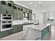 Elegant kitchen featuring quartz countertops, green cabinets, and stainless steel appliances, with a modern design at 17916 Palmiste Dr, Bradenton, FL 34202