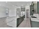 Spacious kitchen with quartz island, green cabinetry, and stainless steel appliances, adjacent to a pantry at 17916 Palmiste Dr, Bradenton, FL 34202
