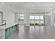Bright living area with lake views, flowing into kitchen with quartz island, and stylish herringbone flooring at 17916 Palmiste Dr, Bradenton, FL 34202