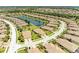 Aerial view of the community featuring a serene pond surrounded by residential homes at 19889 Benissimo Dr, Venice, FL 34293