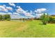 Picturesque backyard view with well-maintained green grass, beautiful landscaping, and a tranquil pond in the distance at 19889 Benissimo Dr, Venice, FL 34293