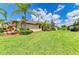 Well-maintained backyard featuring lush green grass, tropical landscaping, and a serene, inviting outdoor space at 19889 Benissimo Dr, Venice, FL 34293