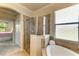 Bright bathroom with a soaking tub, walk-in shower, and view of the Primary bedroom at 19889 Benissimo Dr, Venice, FL 34293