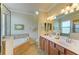 Bright bathroom with double sinks, a soaking tub, and a glass enclosed shower at 19889 Benissimo Dr, Venice, FL 34293