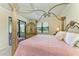 Bedroom with a four poster bed, access to the pool deck, and views of the outdoors at 19889 Benissimo Dr, Venice, FL 34293