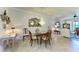 Bright dining room with a glass top table, chandelier, decorative mirror, and access to the living room at 19889 Benissimo Dr, Venice, FL 34293