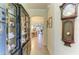 Elegant hallway with tiled flooring, decorative cabinet, and an archway leading to a dining area at 19889 Benissimo Dr, Venice, FL 34293