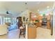 Open kitchen bar area with stainless appliances, granite countertop, and seamless flow to the living room at 19889 Benissimo Dr, Venice, FL 34293