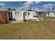 Backyard image of the exterior shows exposed cement slab, and partial fencing and an overgrown yard at 2061 Georgia Ave, Englewood, FL 34224