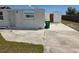 Backyard view of the exterior, with trash can, and cement walkway with green grass at 2061 Georgia Ave, Englewood, FL 34224