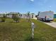 A view of the front yard, showing the lawn, bushes, and a van in the driveway of the house at 2061 Georgia Ave, Englewood, FL 34224