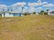 Picture of a large vacant lot with some grasses and weeds with blue skies and clouds at 2061 Georgia Ave, Englewood, FL 34224