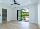 Bright bedroom with light floors, a ceiling fan, and sliding glass doors to a private balcony at 2375 Floyd St, Sarasota, FL 34239