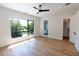 Bright bedroom with hardwood floors, ceiling fan and view of the ensuite bathroom at 2375 Floyd St, Sarasota, FL 34239