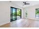 Bedroom featuring light floors, a ceiling fan, and sliding glass doors to a private balcony at 2375 Floyd St, Sarasota, FL 34239