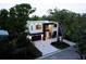 Aerial view of modern two-story home with dark trim, lush landscaping, and a paver driveway at 2375 Floyd St, Sarasota, FL 34239