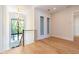Hallway featuring light wood floors, modern chandelier, and natural light at 2375 Floyd St, Sarasota, FL 34239