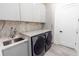 Modern laundry room with marble backsplash, gray cabinets, gray countertops, and stainless steel appliances at 2375 Floyd St, Sarasota, FL 34239