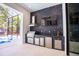 Outdoor kitchen features stainless steel appliances, sleek countertops, and black marble accent wall at 2375 Floyd St, Sarasota, FL 34239