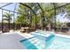 Inviting pool with integrated spa, outdoor dining area, and screened enclosure at 2375 Floyd St, Sarasota, FL 34239