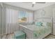 Comfortable bedroom with white furniture, turquoise accents, and natural light from the window at 2752 Riverbluff Pl # 66, Sarasota, FL 34231