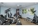 Bright gym with various exercise equipment under a ceiling fan and view of the trees outside the windows at 2752 Riverbluff Pl # 66, Sarasota, FL 34231