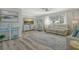 Bright living room with gray laminate floors, coastal decor, and large windows at 2752 Riverbluff Pl # 66, Sarasota, FL 34231