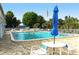 Community pool, fully furnished, with a nearby table for relaxing while enjoying the weather at 2752 Riverbluff Pl # 66, Sarasota, FL 34231