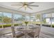 Bright sunroom with a ceiling fan, round dining table, and expansive windows overlooking the landscaped outdoors at 2752 Riverbluff Pl # 66, Sarasota, FL 34231