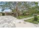 Inviting home exterior featuring a large shade tree, well-maintained lawn, and a driveway leading to an attached garage at 2815 Mayflower St, Sarasota, FL 34231