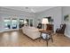 Comfortable living room with a tray ceiling, wood floors, and view of the pool at 284 Lookout Point Dr, Osprey, FL 34229