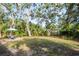 A large backyard space with grass, shade trees, and a patio with a table at 2933 Mayflower St, Sarasota, FL 34231