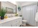 Bright bathroom featuring a large mirror, white vanity, and shower with striped curtain at 2933 Mayflower St, Sarasota, FL 34231