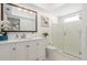 Clean, bright bathroom with white vanity, framed mirror, glass-enclosed shower, and modern fixtures at 2933 Mayflower St, Sarasota, FL 34231