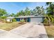 Exterior view of blue home featuring a large driveway, landscaping, and a two-car garage at 2933 Mayflower St, Sarasota, FL 34231