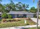 Charming single-story home with a well-manicured lawn, lush landscaping, and a welcoming walkway leading to the front door at 2933 Mayflower St, Sarasota, FL 34231