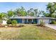 Charming blue home featuring a well-maintained front yard with mature trees and landscaping at 2933 Mayflower St, Sarasota, FL 34231