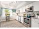 Modern kitchen with stainless steel appliances, white cabinetry, granite countertops, and a bright window overlooking the yard at 2933 Mayflower St, Sarasota, FL 34231