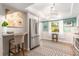 Well-lit kitchen with a stainless steel refrigerator, white cabinets, and a cozy breakfast bar at 2933 Mayflower St, Sarasota, FL 34231