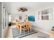 Bright dining area featuring large windows with backyard view, ceiling fan, and an ocean wave painting adjacent to kitchen at 2933 Mayflower St, Sarasota, FL 34231