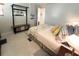 Bedroom features a queen-sized bed, bench storage, wall mirror, and beach-themed artwork at 3414 Spanish Oak Ter, Sarasota, FL 34237