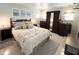 Comfortable bedroom featuring a queen-sized bed, an armoire with a mirrored door, and matching nightstands at 3414 Spanish Oak Ter, Sarasota, FL 34237