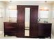 Bedroom featuring armoire with mirrored door, and matching nightstands and a neutral color scheme at 3414 Spanish Oak Ter, Sarasota, FL 34237