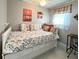 Daybed in bedroom featuring sunset-themed artwork, natural light, and charming window accents at 3414 Spanish Oak Ter, Sarasota, FL 34237