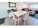 Dining room with white table and chairs, and a red sofa in the background at 3414 Spanish Oak Ter, Sarasota, FL 34237