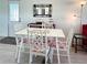 Bright dining area with white table, chairs, and a decorative mirror on the wall at 3414 Spanish Oak Ter, Sarasota, FL 34237