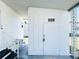 Exterior view of home with white walls, covered porch, and storage area, located on a well maintained lot at 3414 Spanish Oak Ter, Sarasota, FL 34237