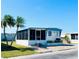 Inviting mobile home with a screened-in porch, complemented by palm trees and well-maintained landscaping at 3414 Spanish Oak Ter, Sarasota, FL 34237