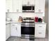 View of stainless steel stove top and oven with white shaker cabinets at 3414 Spanish Oak Ter, Sarasota, FL 34237